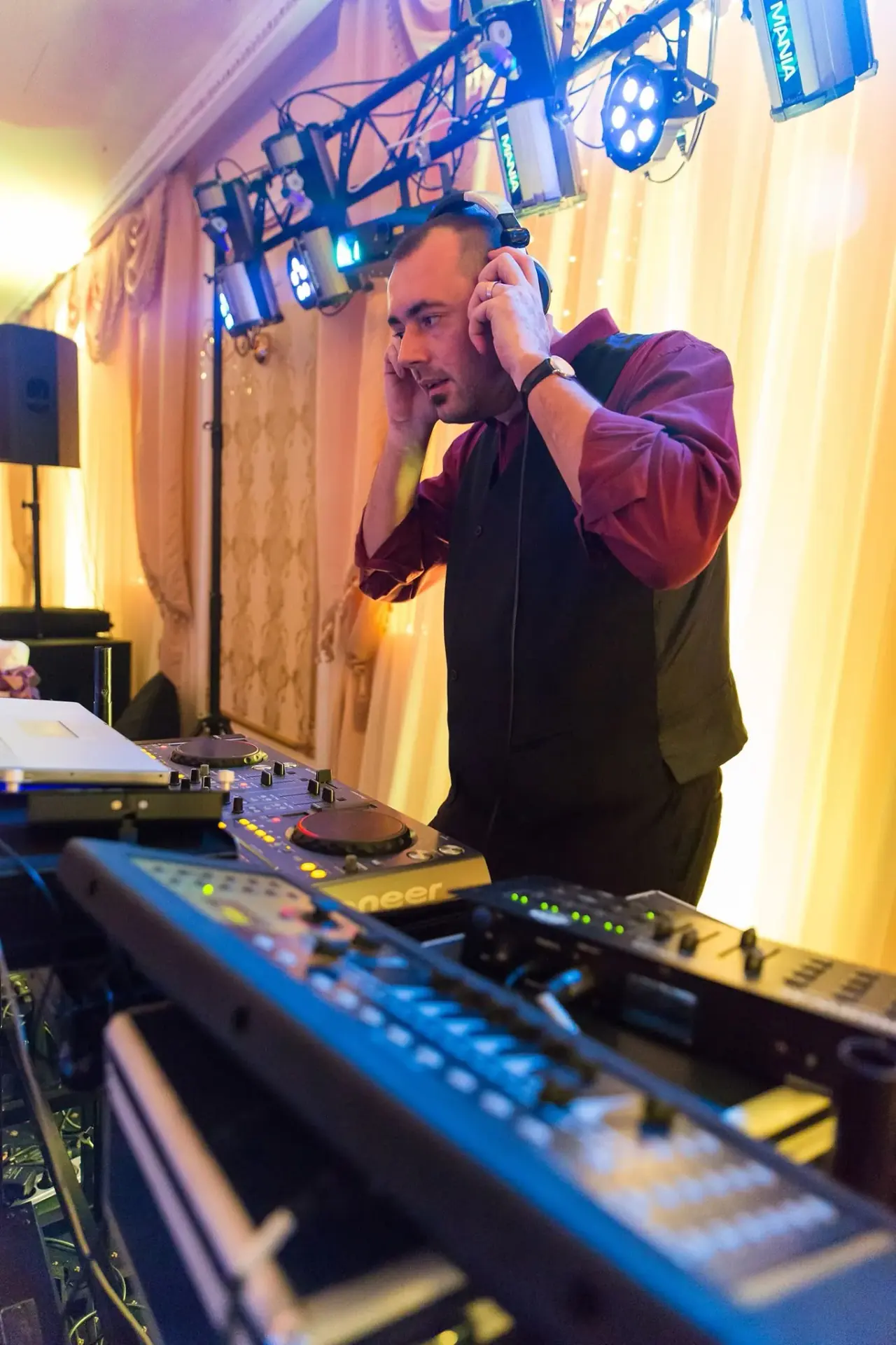 DJ Florin Popescu cu căștile la ureche, mixând la o nuntă